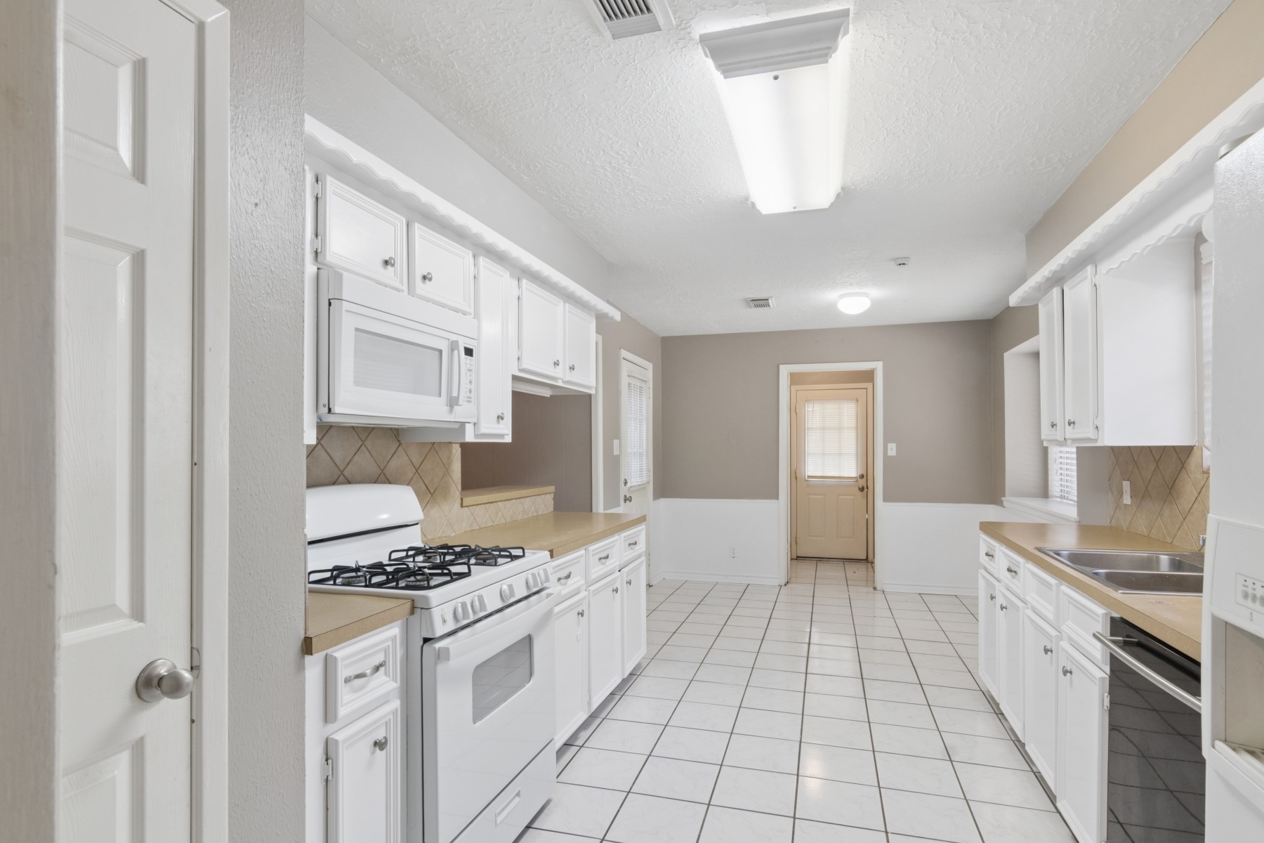 2607 Allyson Court Spring, TX 77373 - Photo 11 of 25 a large white kitchen with cabinets