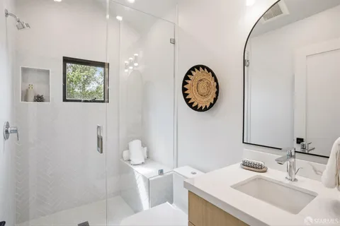 a bathroom with a toilet a sink and mirror