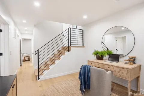 a hallway with a potted plant and a wooden floor