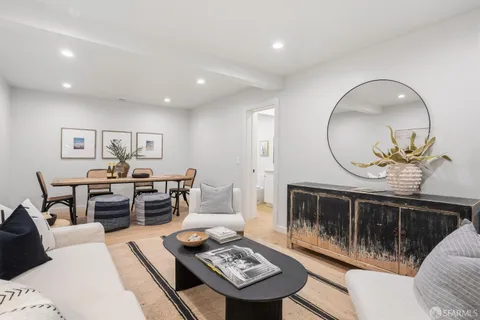 a living room with furniture a table and kitchen view