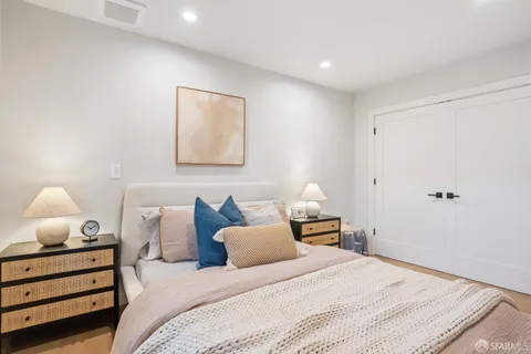a bedroom with bed and a lamp on dresser