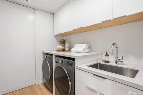 a utility room with sink dryer and washer