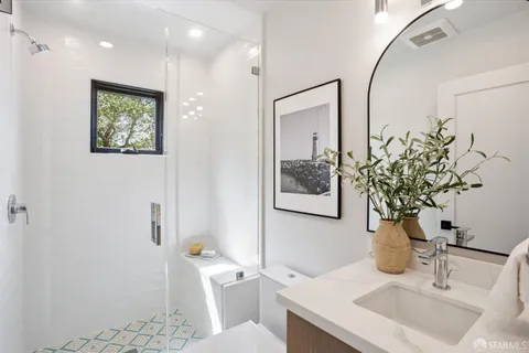 a bathroom with a sink and mirror with toilet