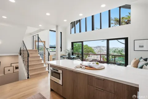a dining hall with stainless steel appliances kitchen island wooden floor and a large window