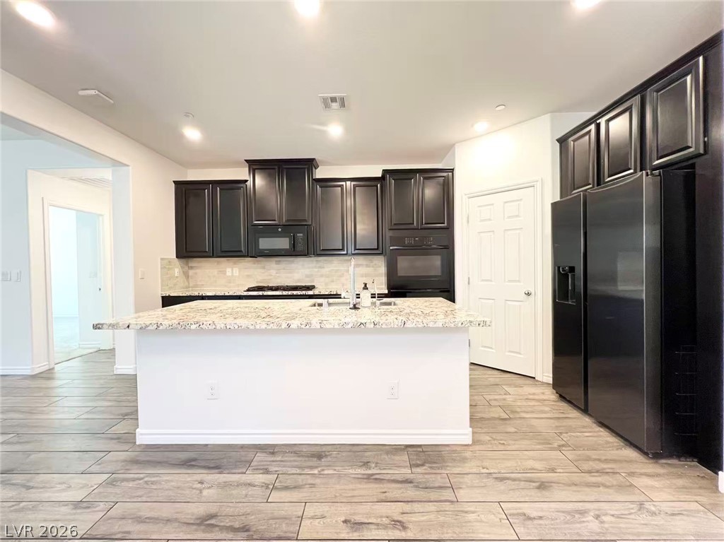 925 Bayberry Ridge Street Henderson, NV 89052 - Photo 3 of 27 A well-appointed kitchen showcasing a spacious island with a sink and ample counter space.
