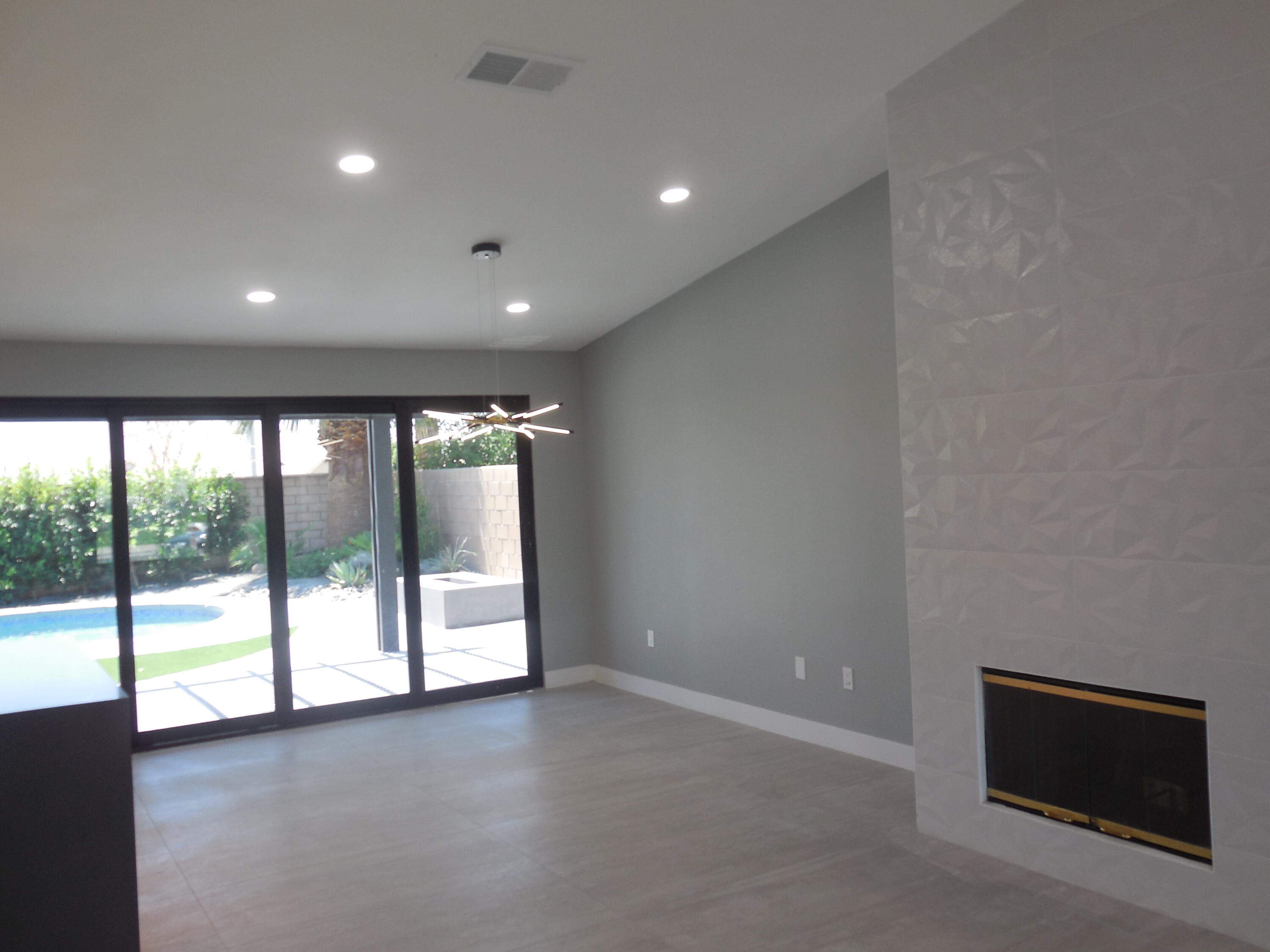 83389 Calypso Circle Indio, CA 92201 - Photo 12 of 45 wooden floor in an empty room with a fireplace and a window