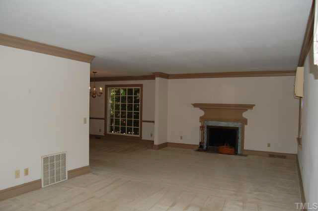 3328 Thomas Road Raleigh, NC 27607 - Photo 3 of 3 an empty room with furniture and a fireplace