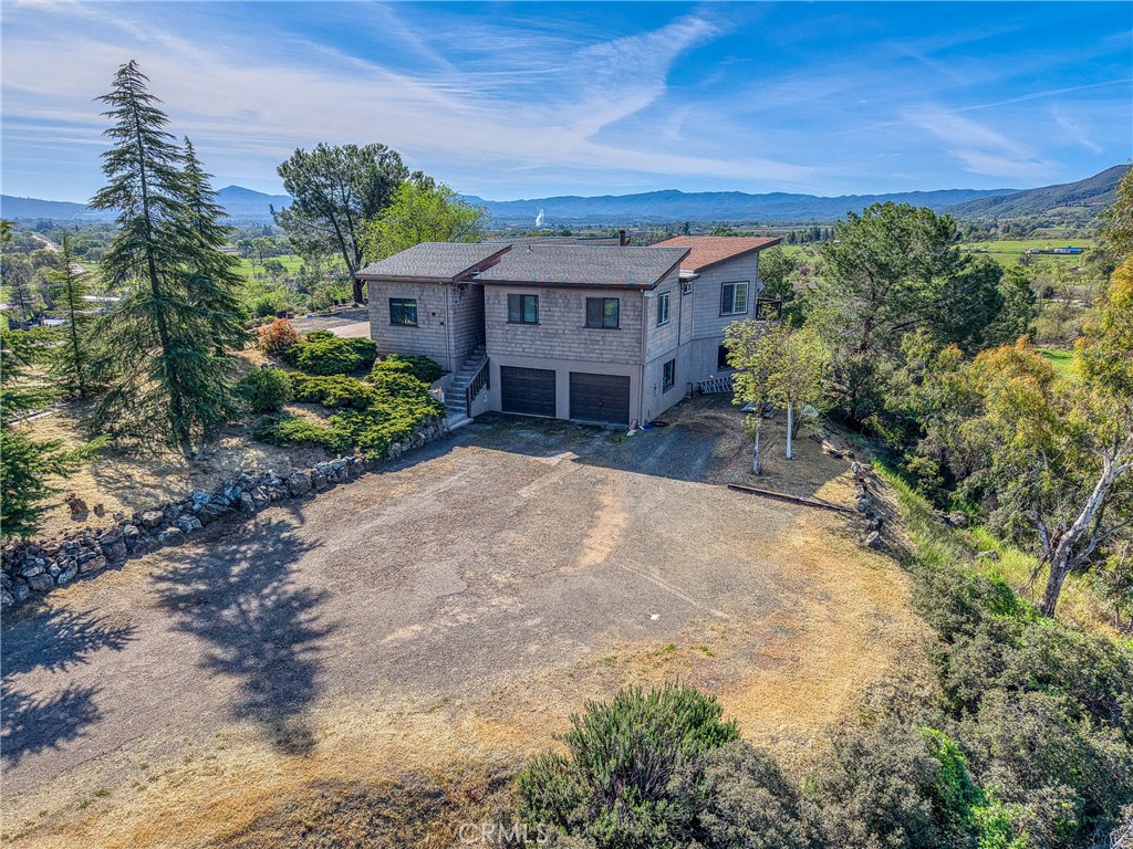 3245 Ackley Road Lakeport, CA 95453 - Photo 12 of 16 a view of a house with a yard and potted plants