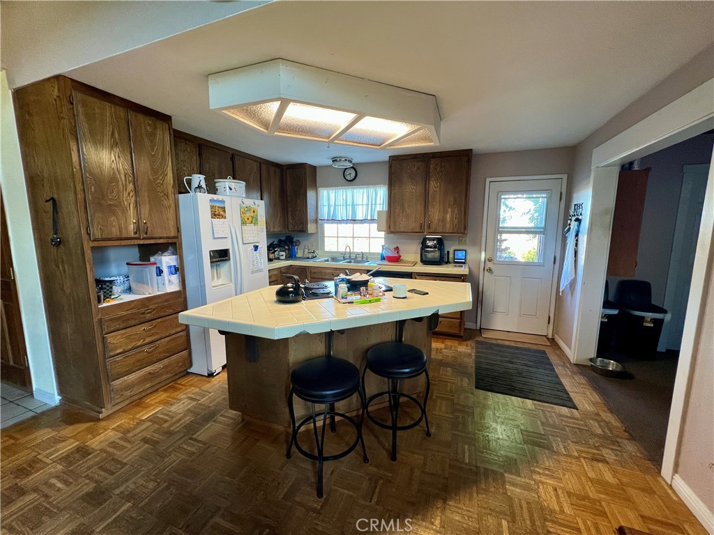 3245 Ackley Road Lakeport, CA 95453 - Photo 4 of 16 a kitchen with stainless steel appliances a dining table chairs refrigerator and sink