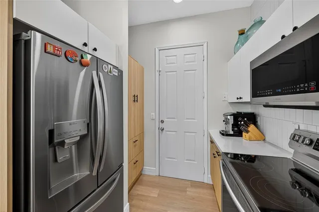 a kitchen with a refrigerator and a stove top oven