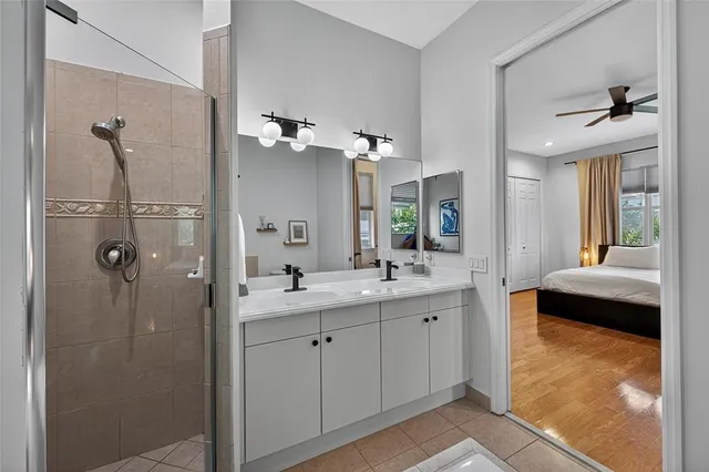 a en suite bathroom with a granite countertop sink mirror and shower