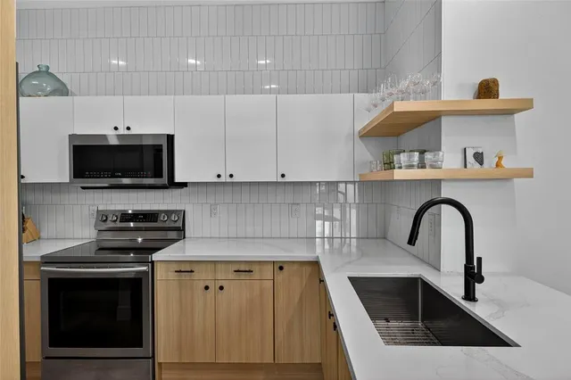 a kitchen with a sink a stove and cabinets