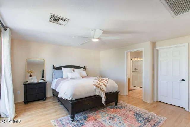 a bedroom with a bed and a dresser with a flat tv screen