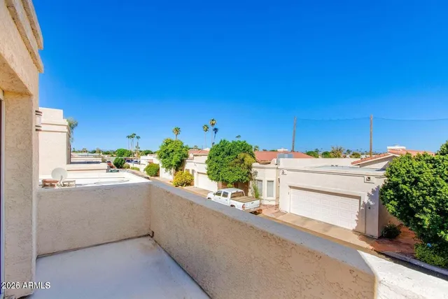 a patio with table and chairs and potted plants