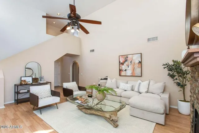 a living room with furniture a fireplace and a large window