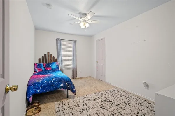a bedroom with a bed a dresser and a chandelier