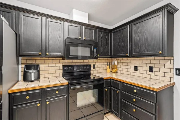a kitchen with granite countertop wood cabinets stainless steel appliances and a sink