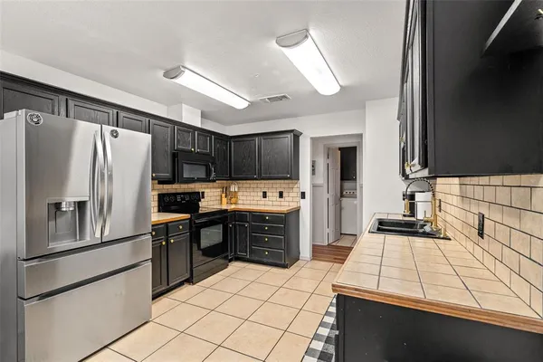a kitchen with granite countertop a sink cabinets and stainless steel appliances