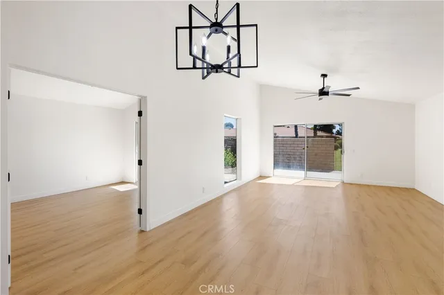 a view of empty room with wooden floor and ceiling fan