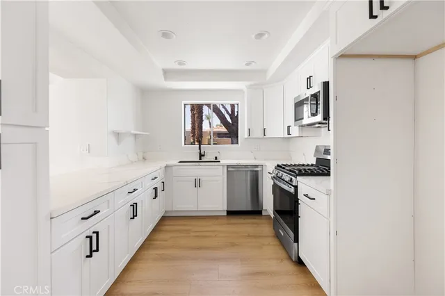 a kitchen with granite countertop a sink and a stove top oven