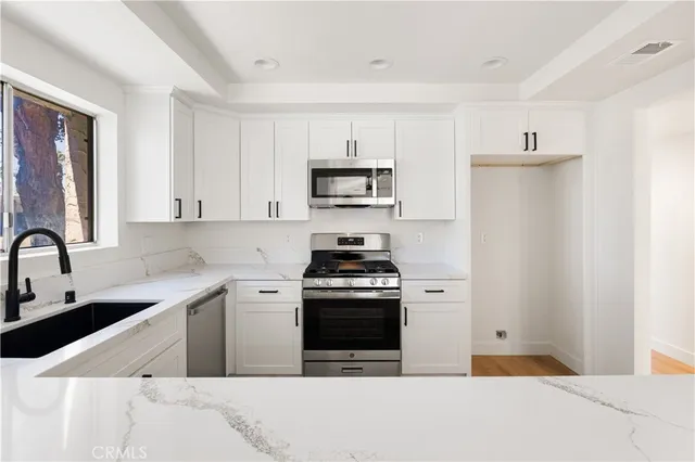 a kitchen with stainless steel appliances a stove a sink and a refrigerator