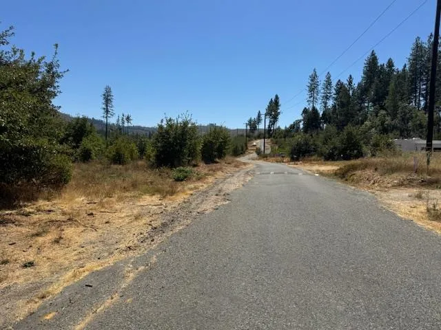 a view of a dirt road with a building in the background