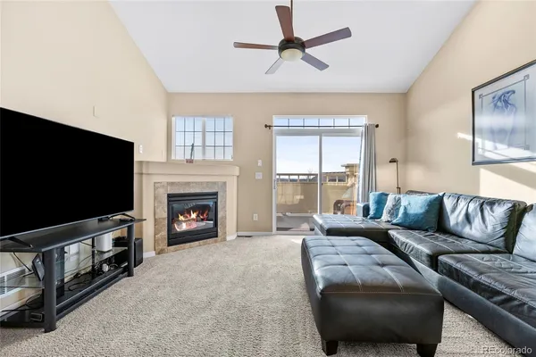 a living room with furniture a flat screen tv and a fireplace