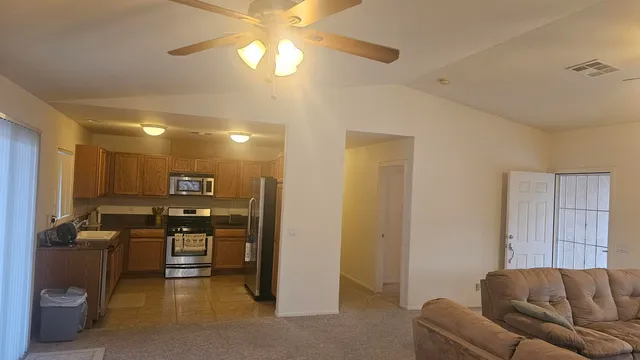 a view of living room with furniture and a ceiling fan