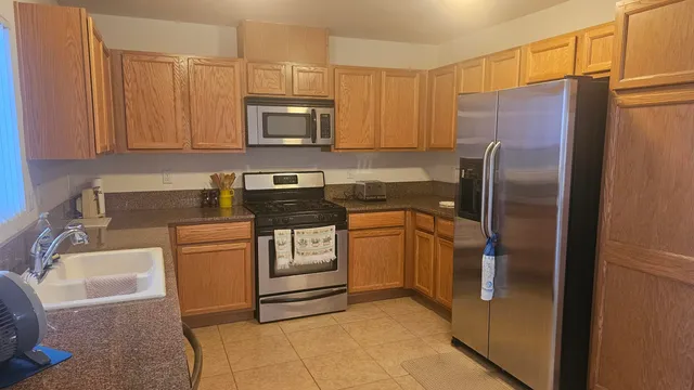 a kitchen with stainless steel appliances granite countertop a refrigerator and a sink