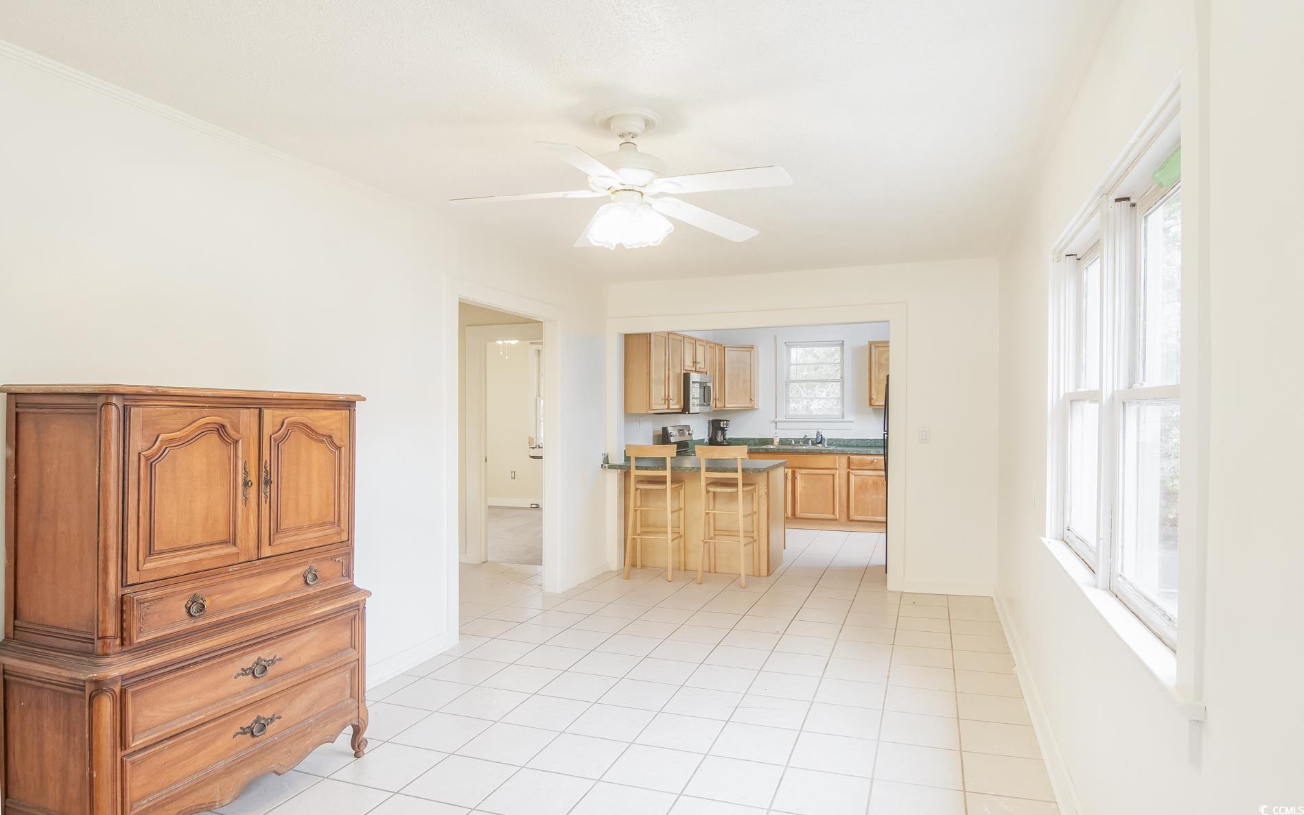 1019 Prince Street Georgetown, SC 29440 - Photo 16 of 20 Kitchen featuring a sink, stainless steel microwave, light tile patterned floors, baseboards, and ceiling fan