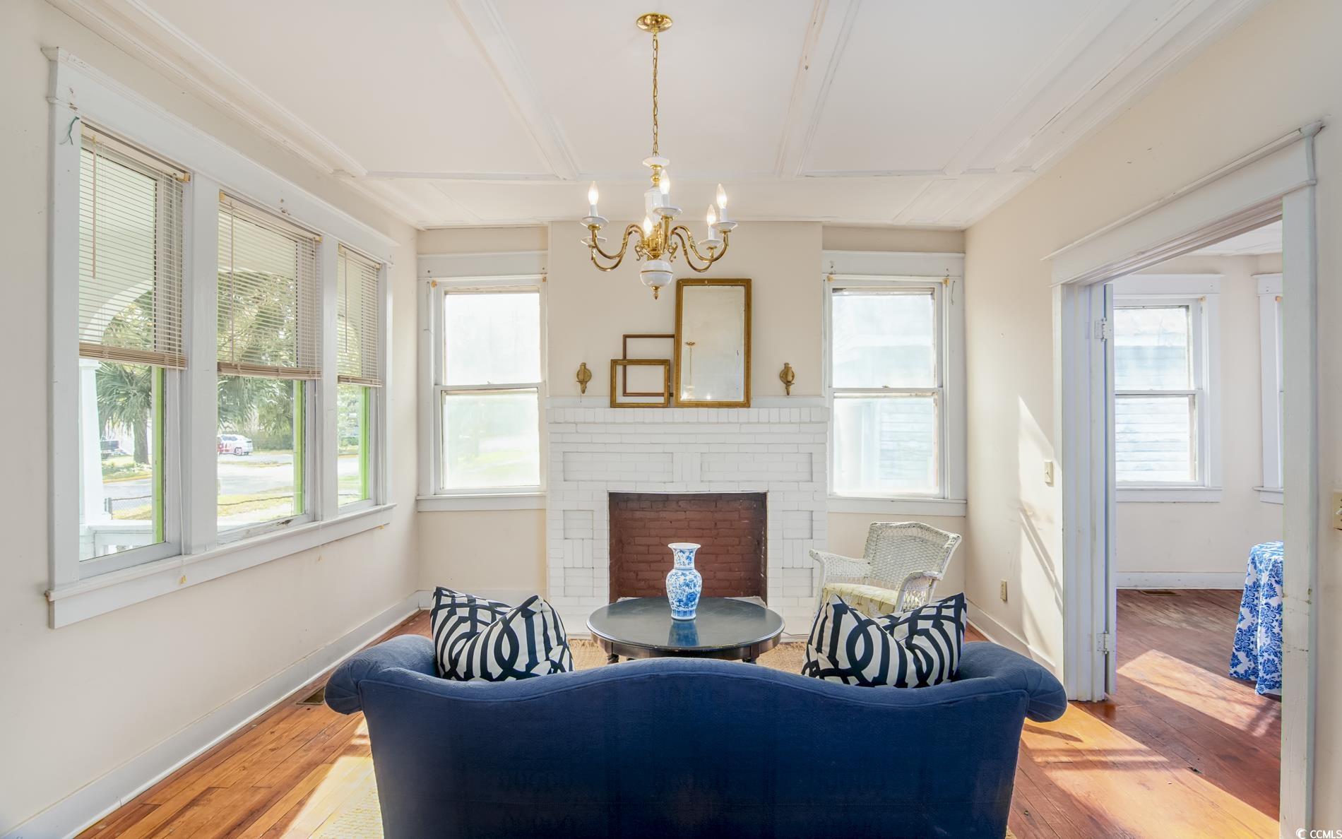 1019 Prince Street Georgetown, SC 29440 - Photo 6 of 22 Living room with a notable chandelier, plenty of natural light, baseboards, and wood finished floors
