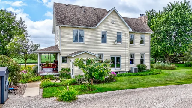 a view of a house with large trees and plants