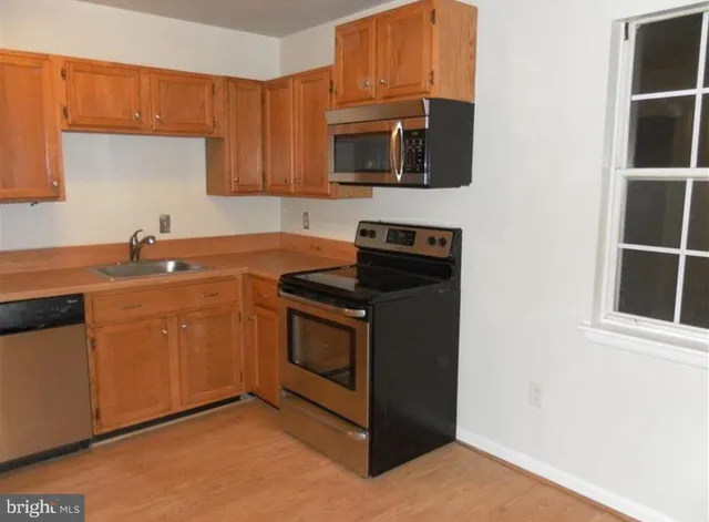 a kitchen with stainless steel appliances granite countertop a sink stove and microwave