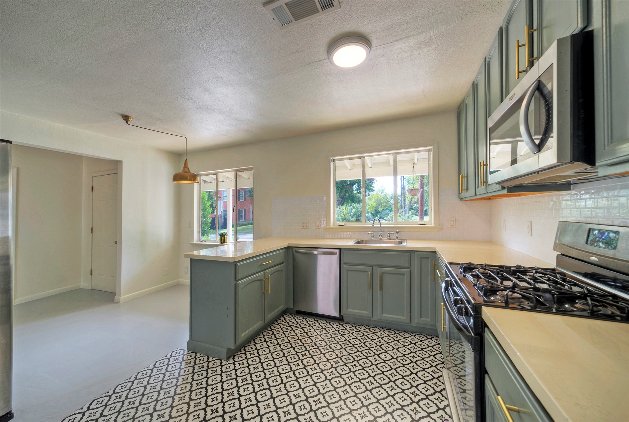 1803 Pearl Street Austin, TX 78701 - Photo 7 of 33 a kitchen with stainless steel appliances granite countertop a stove a sink and a microwave