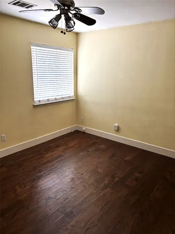 a view of a room with wooden floor and a window