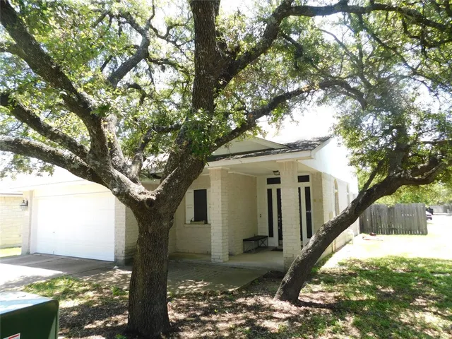 a view of a house with a tree in the background