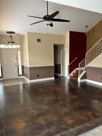 a view of a livingroom with wooden floor and a ceiling fan