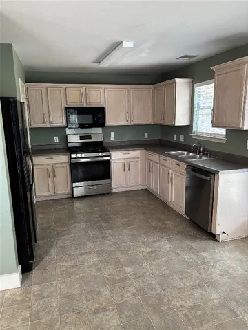 a kitchen with stainless steel appliances granite countertop a stove a sink and a microwave