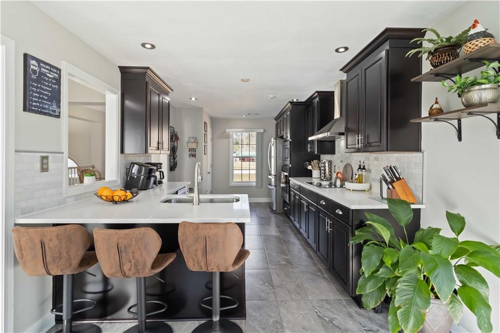 180 Harper Road McDonough, GA 30252 - Photo 13 of 63 a kitchen with kitchen island granite countertop a table chairs stainless steel appliances and cabinets