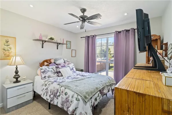 a living room with furniture a flat screen tv and kitchen view