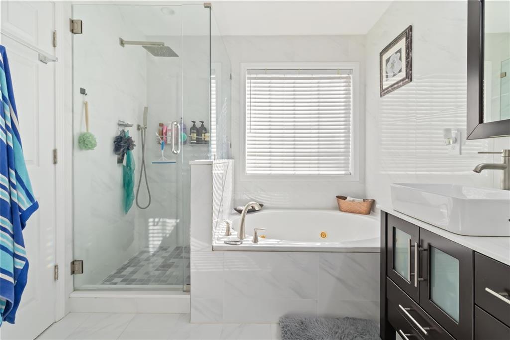 180 Harper Road McDonough, GA 30252 - Photo 35 of 63 a bathroom with a tub sink and a shower