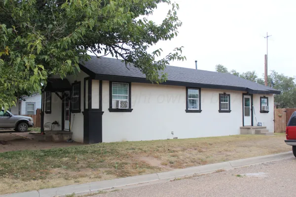 a front view of a house with a tree