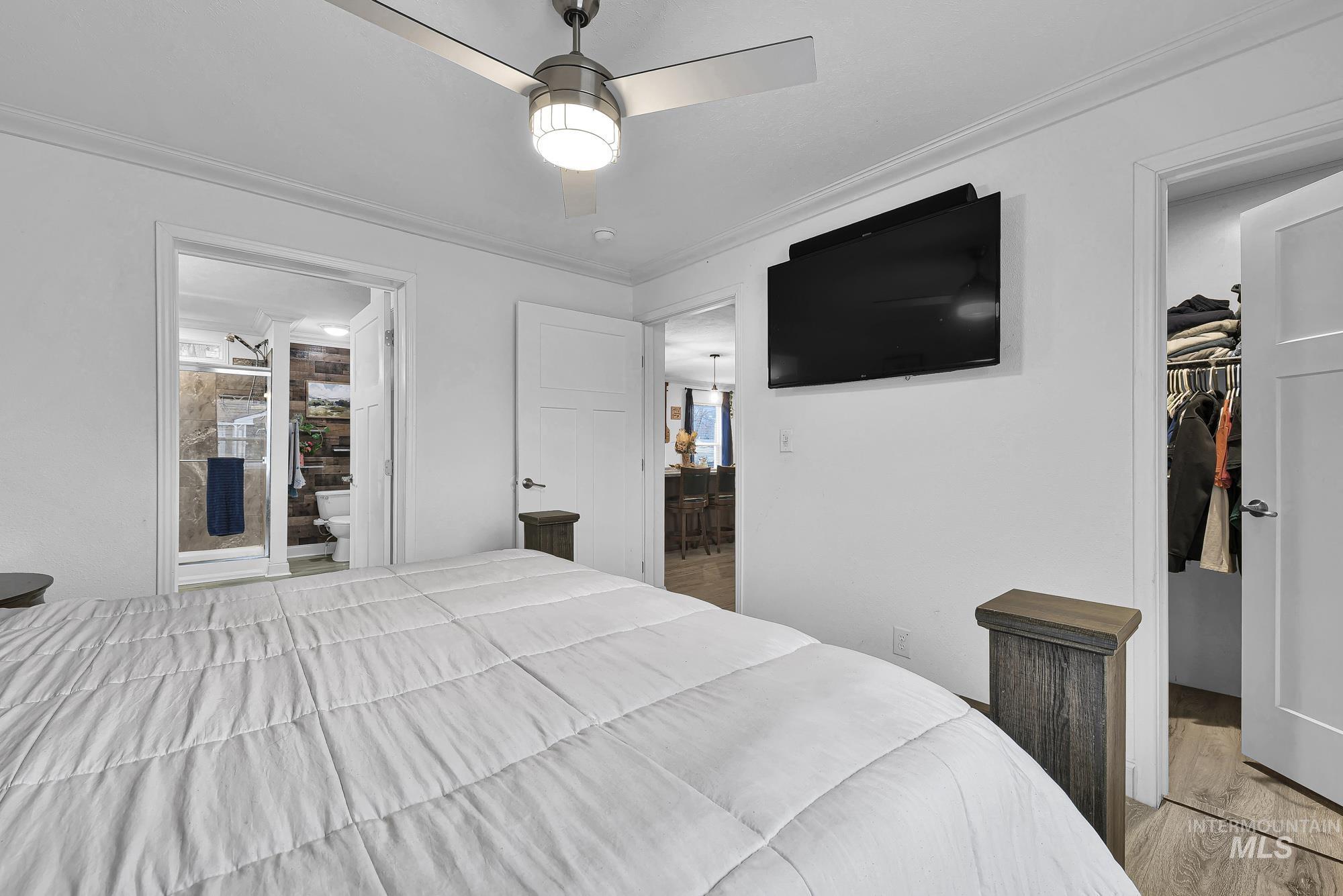 8483 West Irving Lane Boise, ID 83704 - Photo 14 of 40 Bedroom featuring a walk in closet, ceiling fan, wood finished floors, and ornamental molding