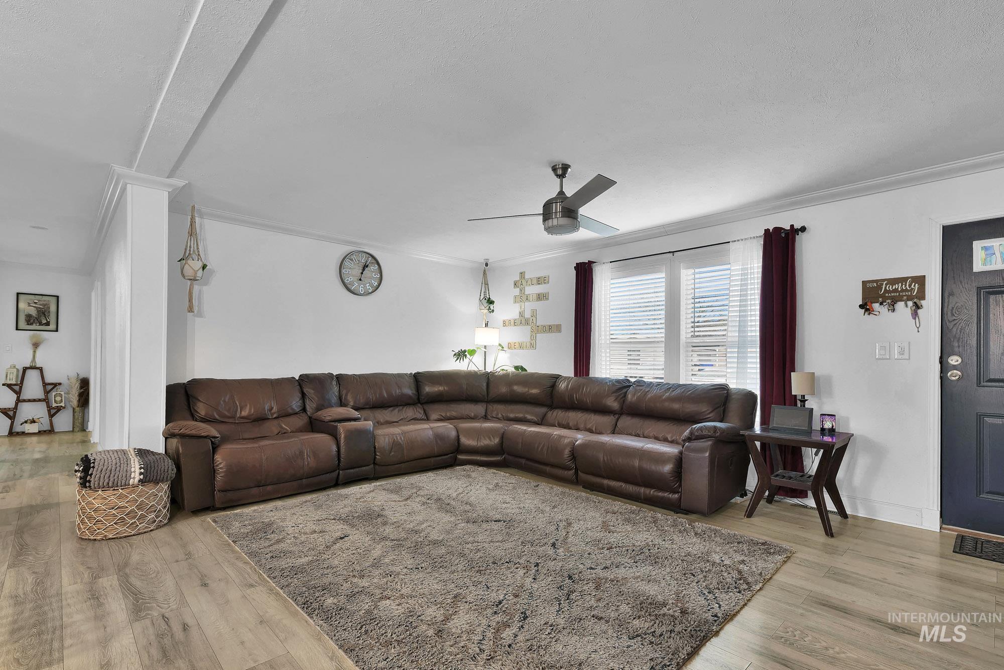 8483 West Irving Lane Boise, ID 83704 - Photo 2 of 40 Living room featuring crown molding, a ceiling fan, and light wood-type flooring
