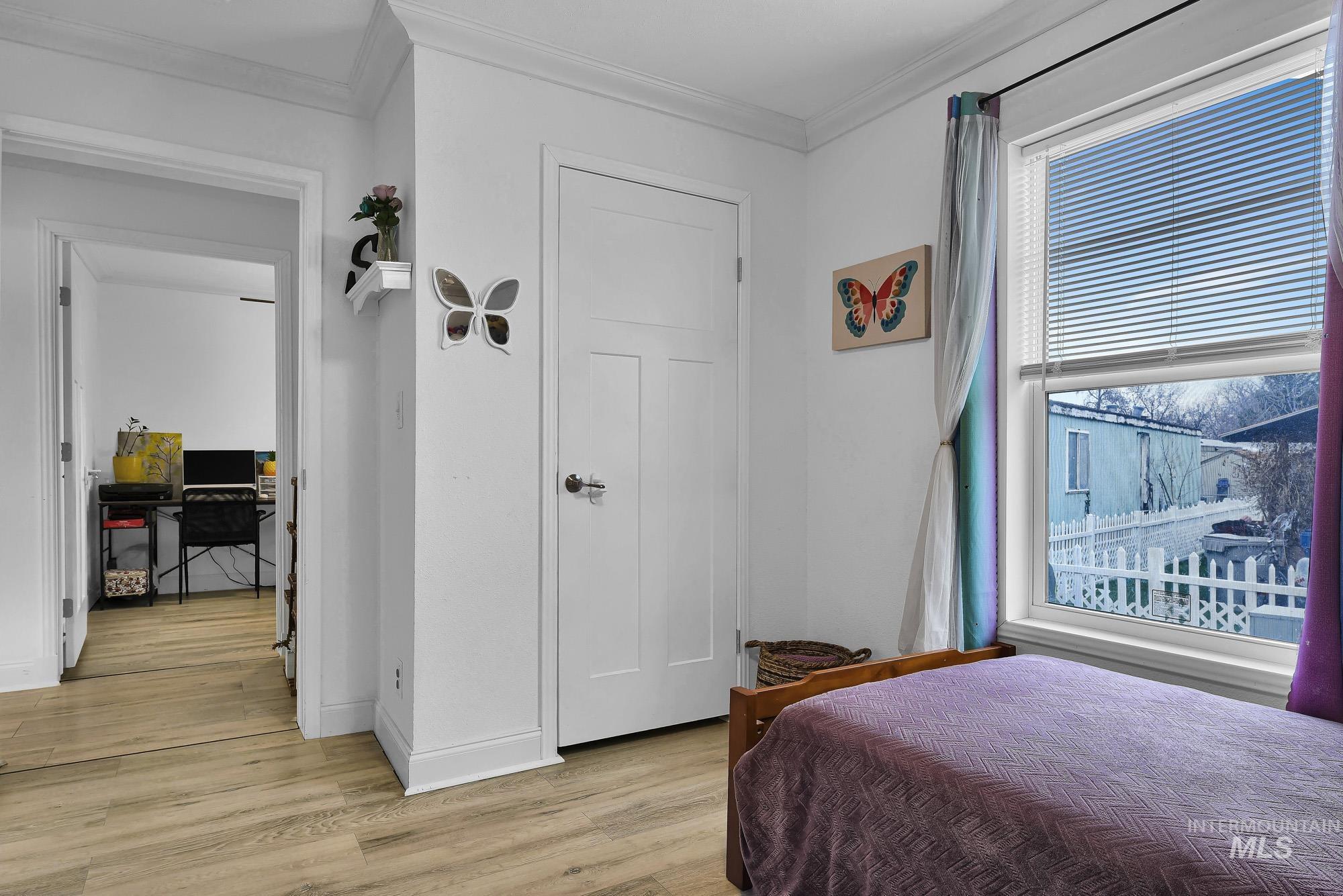 8483 West Irving Lane Boise, ID 83704 - Photo 21 of 40 Bedroom with light wood-style floors, crown molding, and an office area