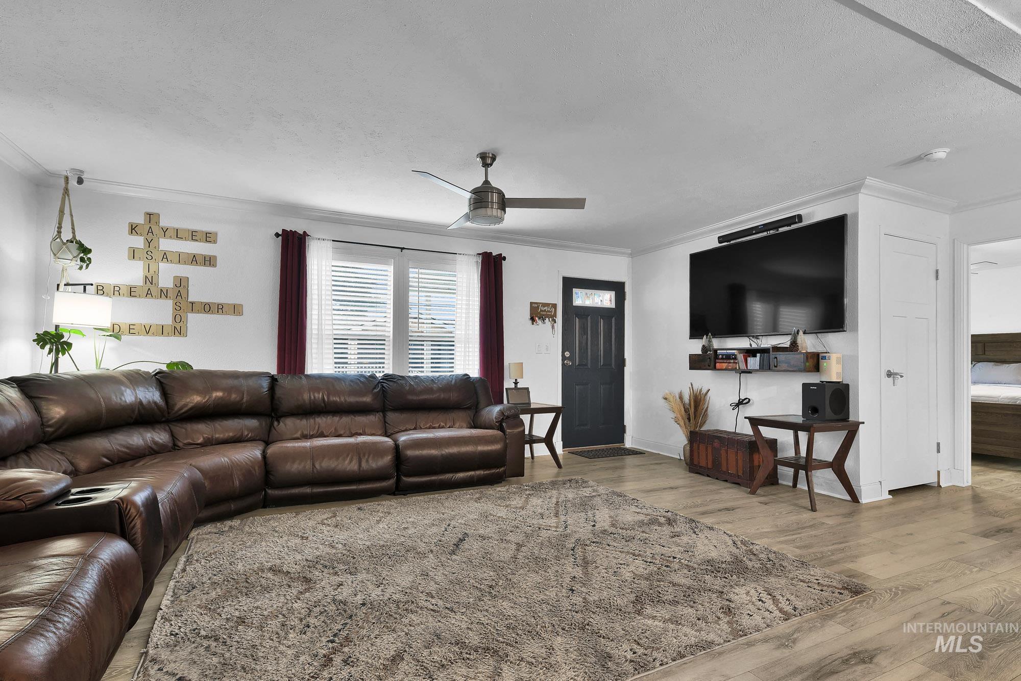 8483 West Irving Lane Boise, ID 83704 - Photo 3 of 40 Living area with ornamental molding, light wood-style flooring, and ceiling fan