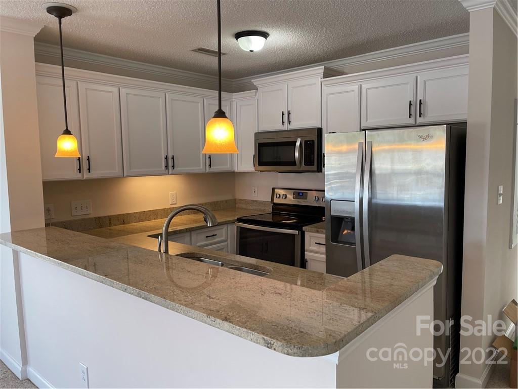 18679 Vineyard Point Lane Cornelius, NC 28031 - Photo 2 of 7 a kitchen with stainless steel appliances granite countertop a sink a stove and a refrigerator