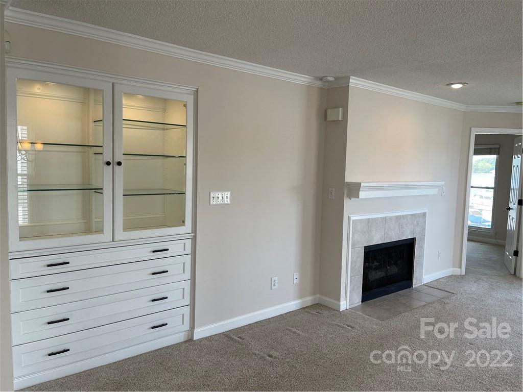 18679 Vineyard Point Lane Cornelius, NC 28031 - Photo 3 of 7 a view of an empty room with cabinet and fireplace