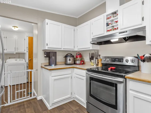 a kitchen with stainless steel appliances granite countertop a stove and white cabinets