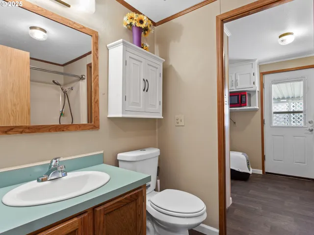 a bathroom with a granite countertop toilet sink and mirror